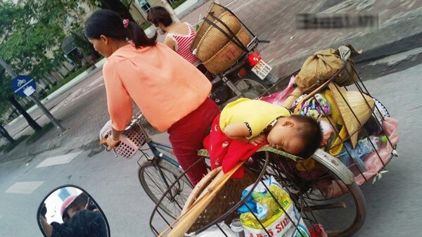 Em bé đang ngủ ngon trên chiếc xe đạp cà tàng của mẹ giữa phố 35 Em bé đang ngủ ngon trên chiếc xe đạp